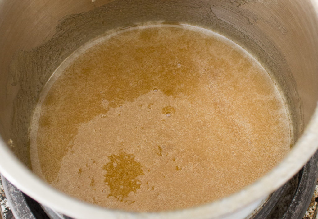 In a pot on the stove, heat your honey and brown sugar, stirring occasionally and bringing it to a boil. Let it boil for three minutes, until its all bubbly and delicious. Make sure to keep stirring! Then turn off the heat and let it sit for a minute or two so you won't hurt yourself pouring it over the popcorn! (Pro-tip, wash the pot and spoon as soon as they've cooled off enough to do it safely, this stuff is like glue once it's hard!)